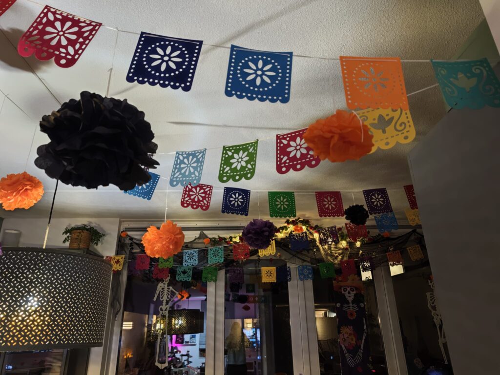 Día de los Muertos versiering met papel picado slingers, marigolds en skeletten bij de achterdeur