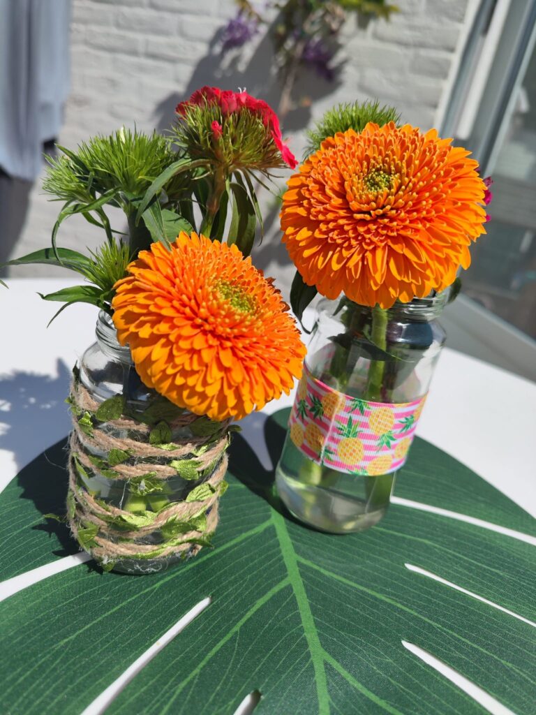 Hawaii tafeldecoratie met grote palmbladen en tropische bloemen